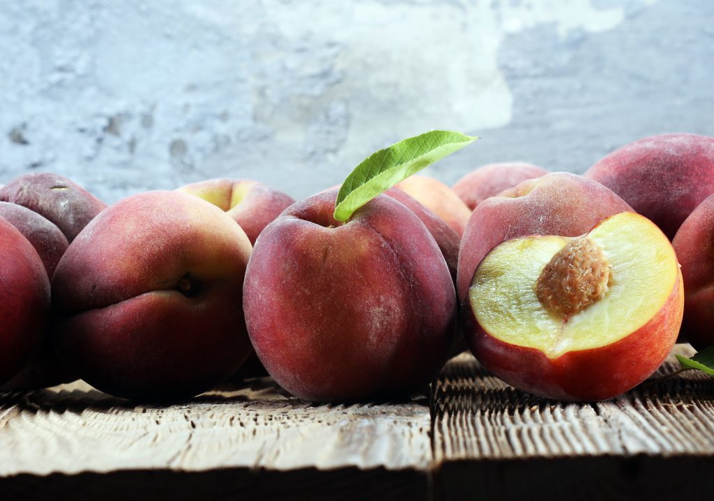 A Group Of Ripe Peaches On Table