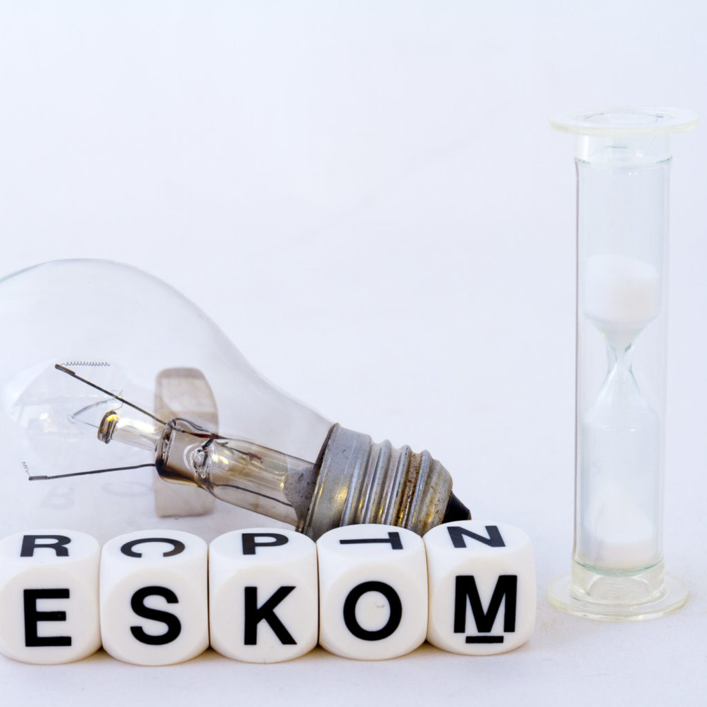 A Fused Electric Light Globe, A Hourglass And The Name Eskom In Black Text On A White Background Image With Copy Space In Landscape Format