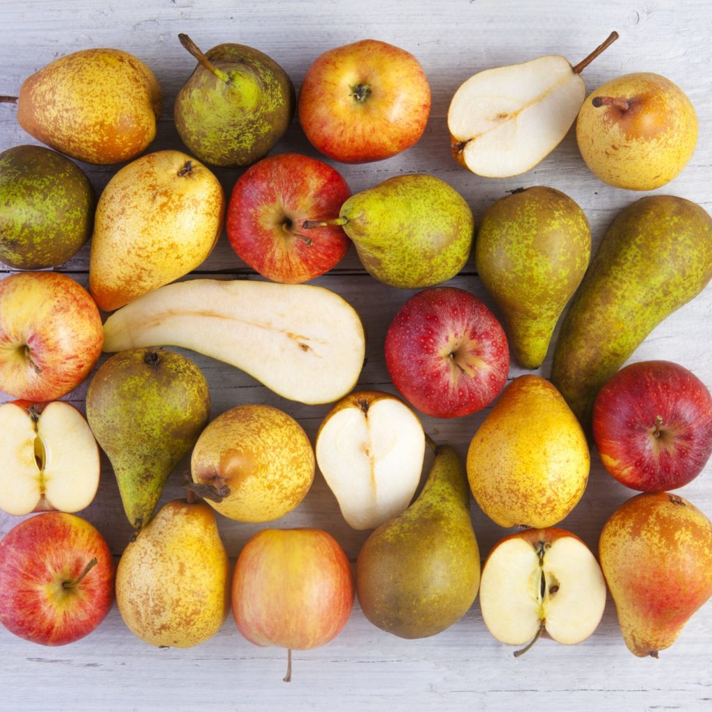 Apples And Pears Whole And Halved Shot From Above On White Wooden Boards
