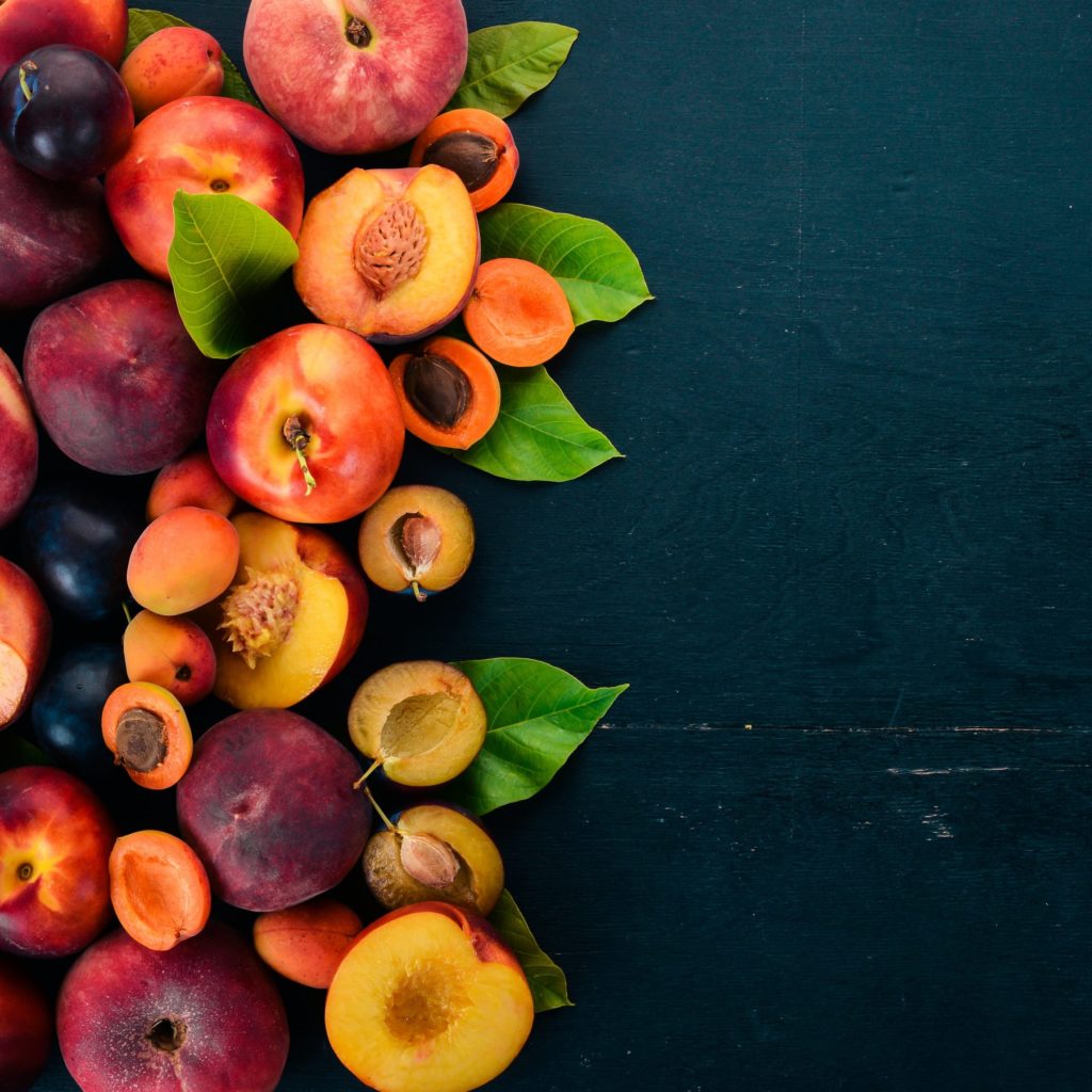 Fresh Fruits. Apricot, Peach, Plums, Nectarines. On A Wooden Background. Top View. Free Space For Your Text.